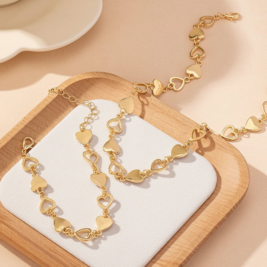 Gold heart-shaped bracelet on a wooden tray with a soft beige background