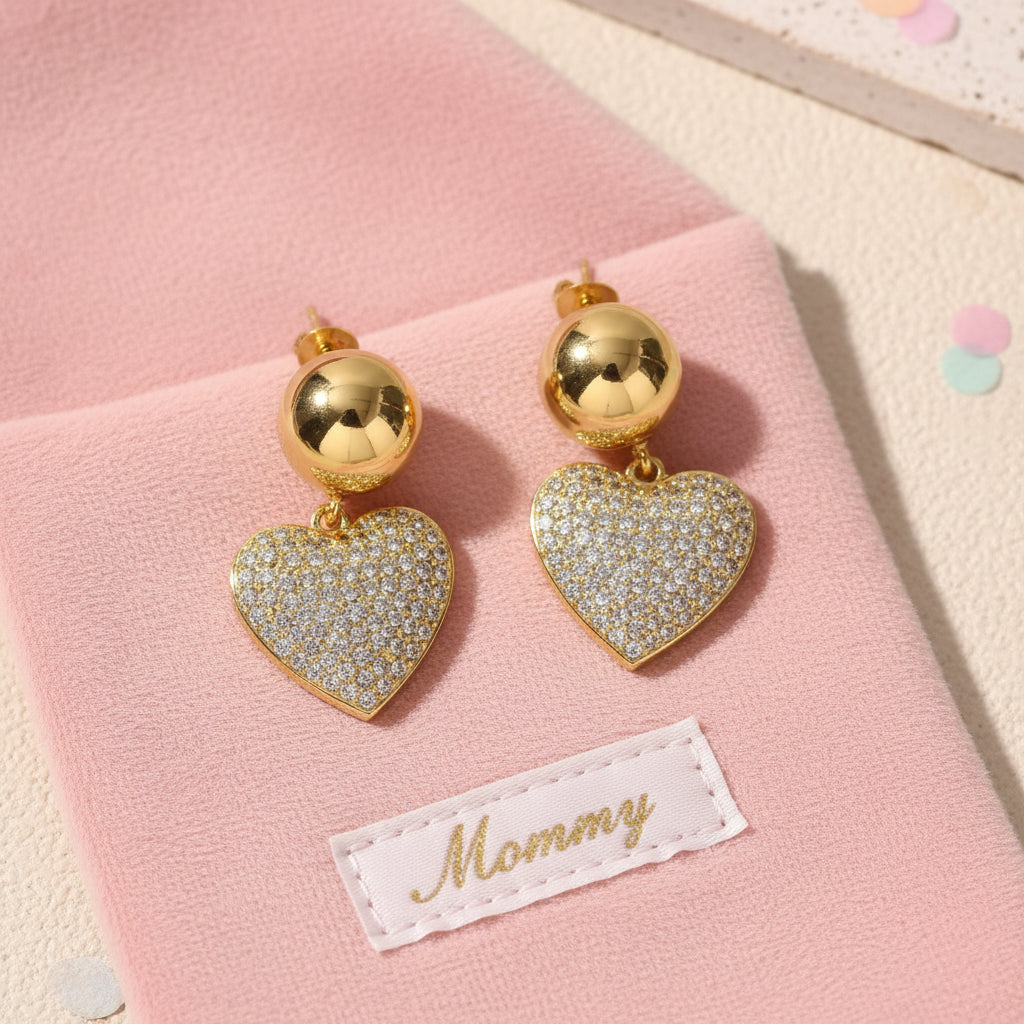 Heart-shaped earrings with gold and diamond details on a light background