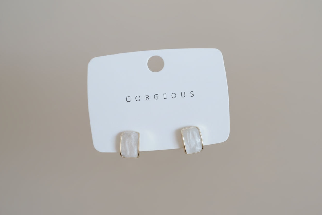 White card with 'NARS' branding held by a hand against a neutral background