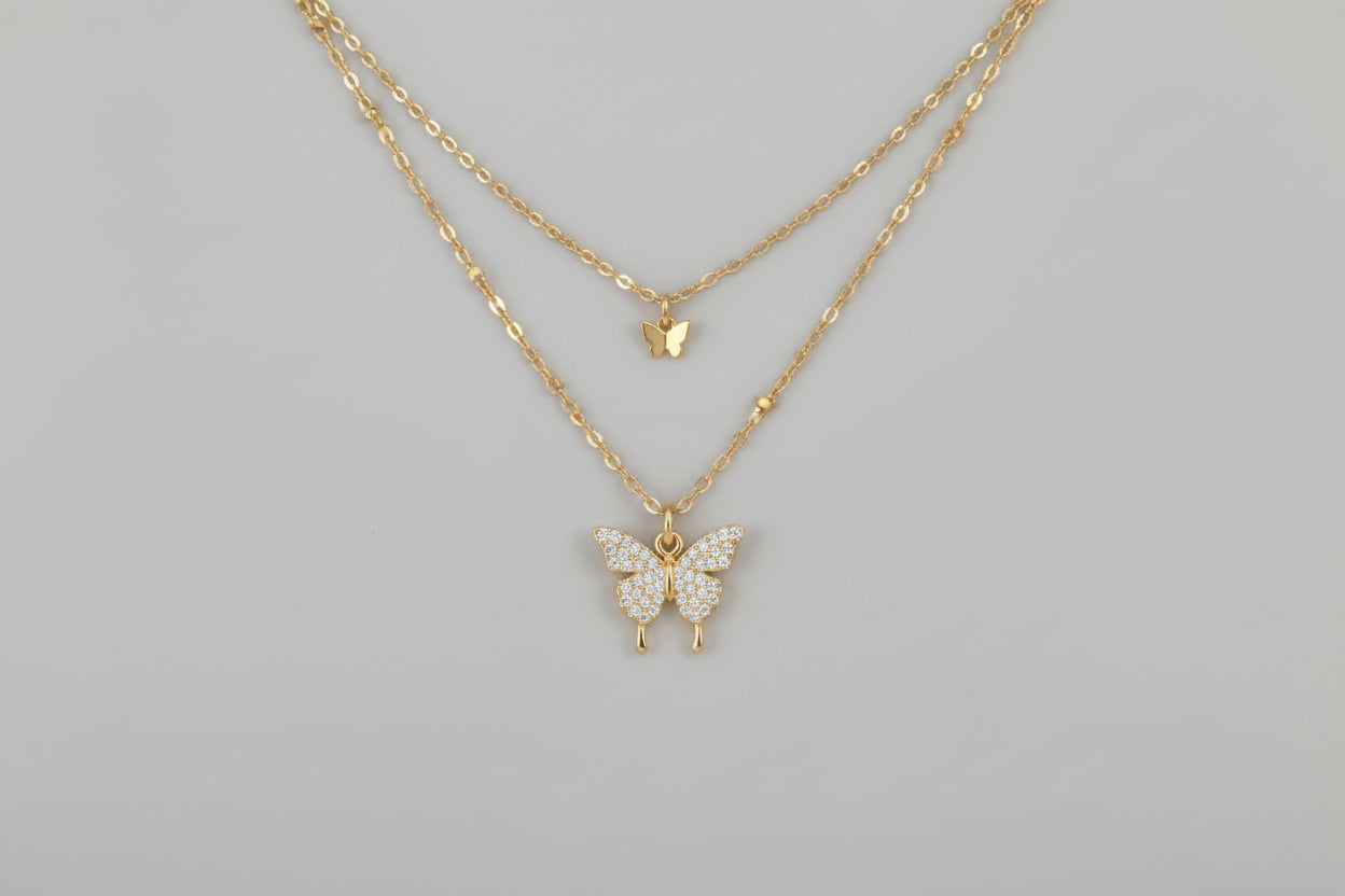 Butterfly-shaped necklace on a hand with a white background