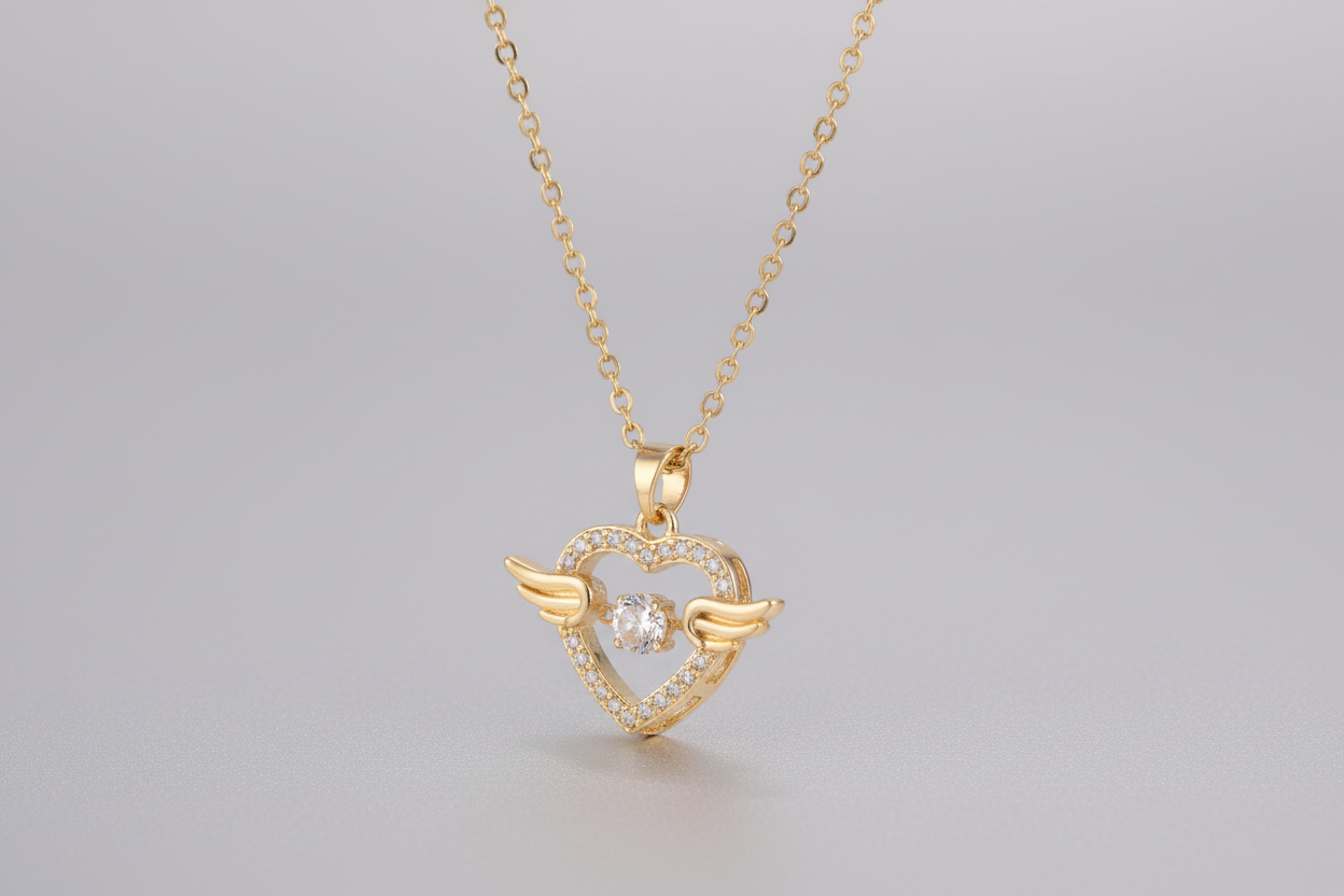 Gold heart-shaped necklace with wings on a white background