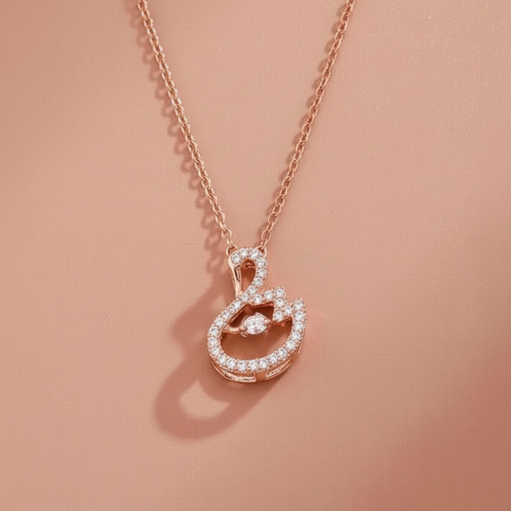 Rose gold necklace with a heart-shaped pendant on a pink background