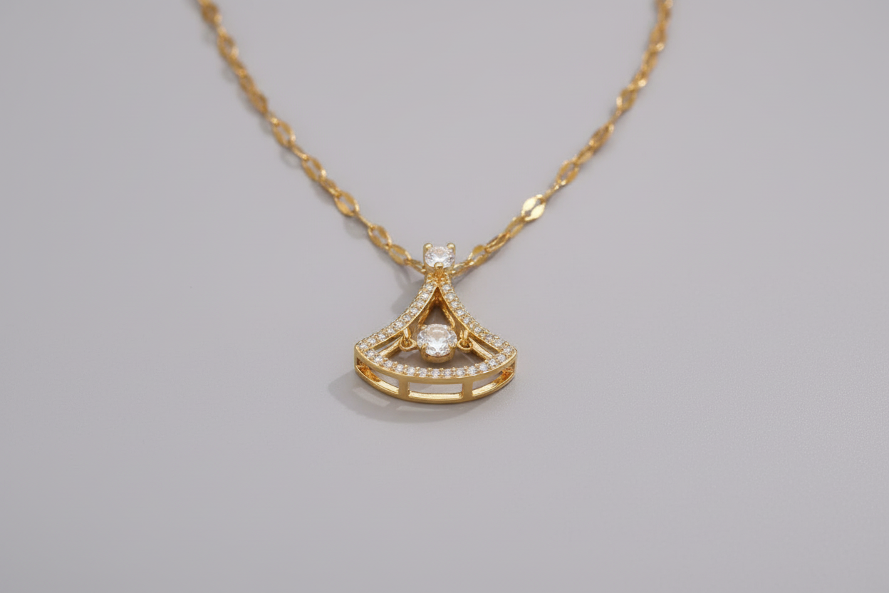 Gold necklace with a detailed pendant on a beige surface