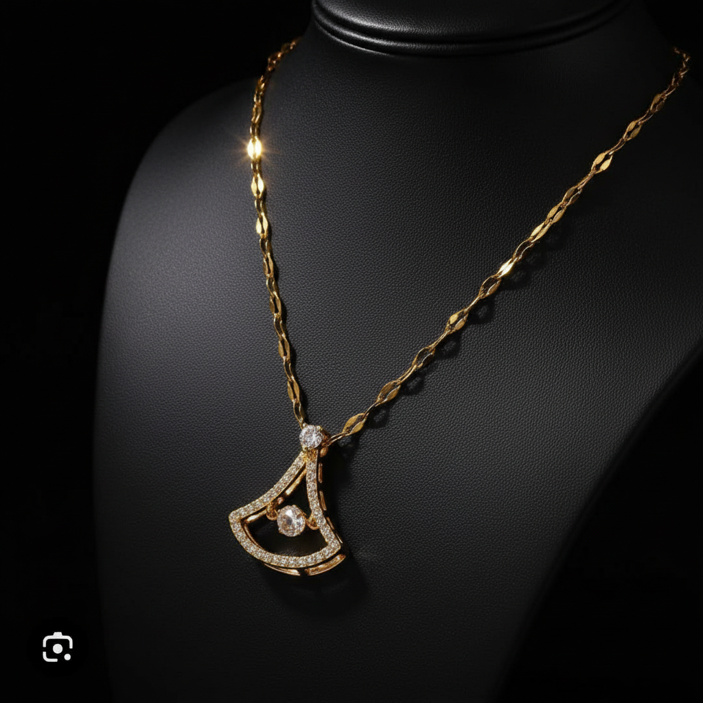 Gold necklace with a detailed pendant on a beige surface