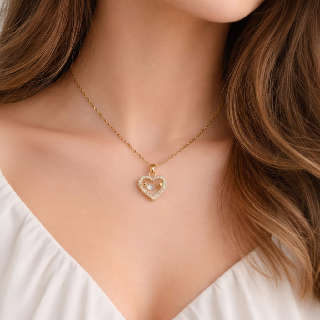 Gold necklace with a heart-shaped pendant worn by a person