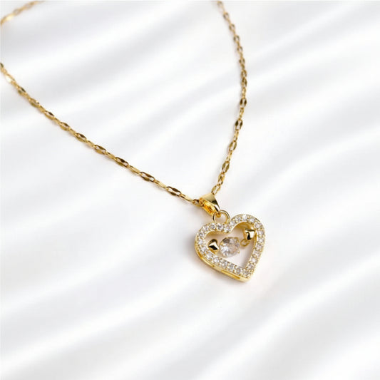 Gold heart-shaped necklace with a clear gemstone on a white background