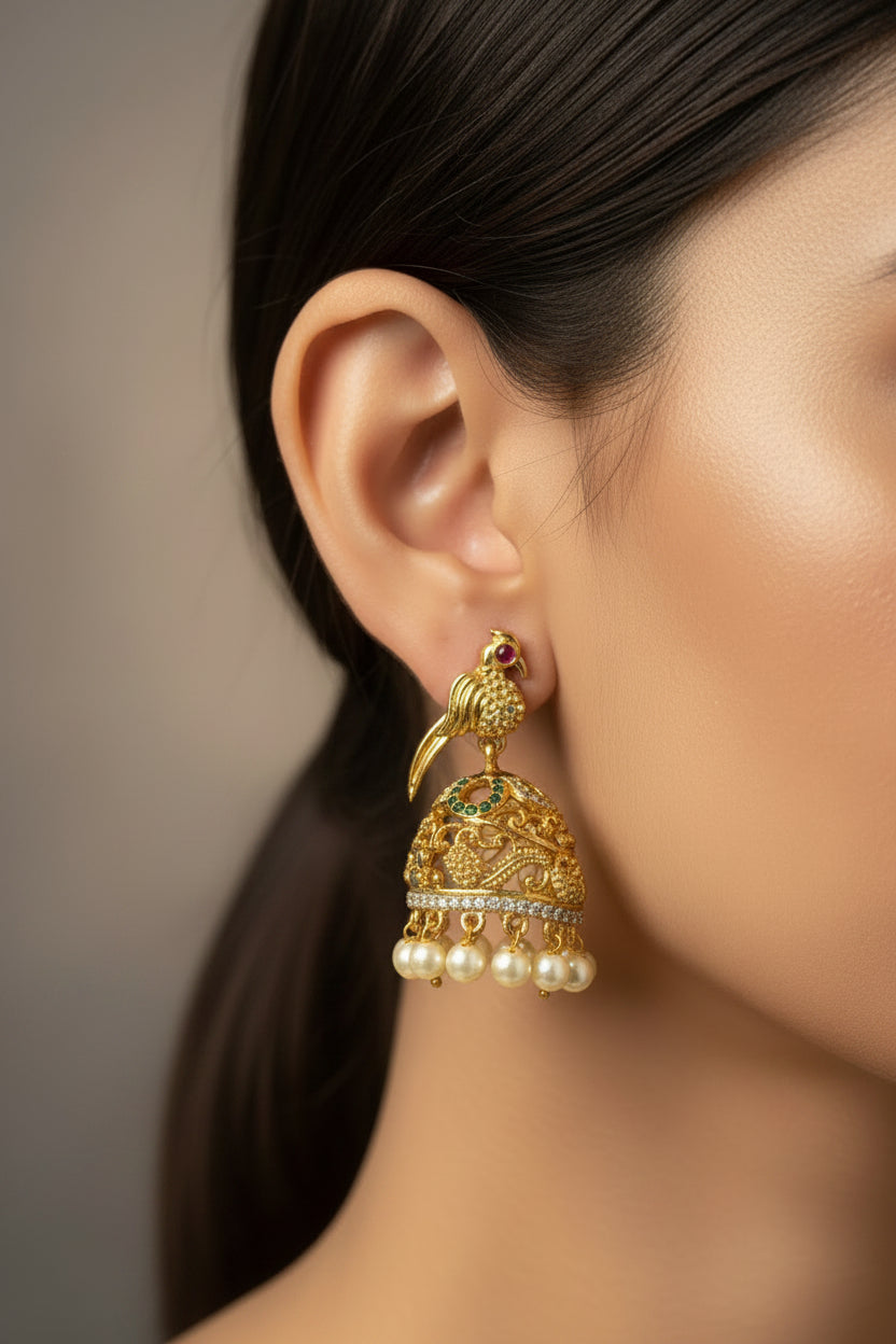 Gold earrings with pearl accents on a Pranvi branded card against a dark background