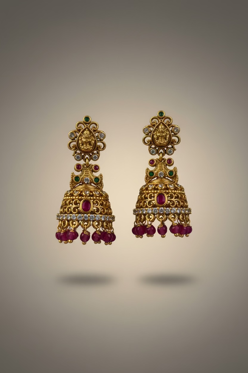 Gold and red earrings on a Pranavi branded card held by a hand against a dark background