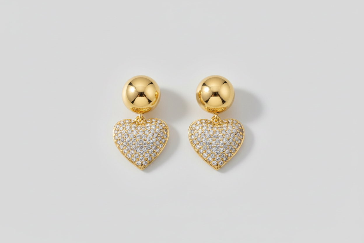 Heart-shaped earrings with gold and diamond details on a light background